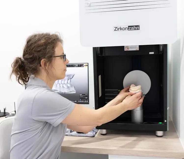 Zahntechnikerin platziert ein 3D-Modell im Scanner